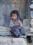 Tibet: Een jongetje zit op de stoep in Shegar - P3Tibet_0676.jpg - Copyright : Ronald van der Veer (http://www.veeronline.nl)